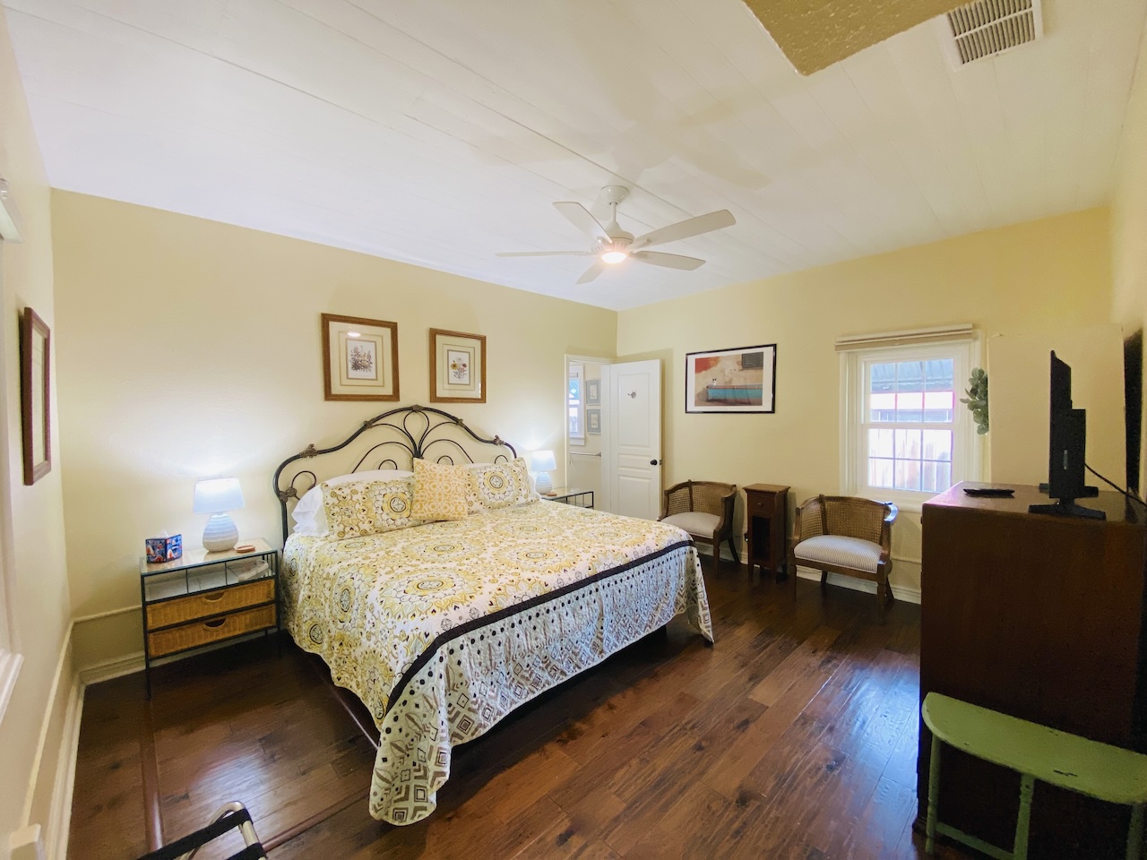 King Bedroom With En Suite Bathroom, Sitting Area, And Shiplap Ceiling In The New Braunfels Cottage