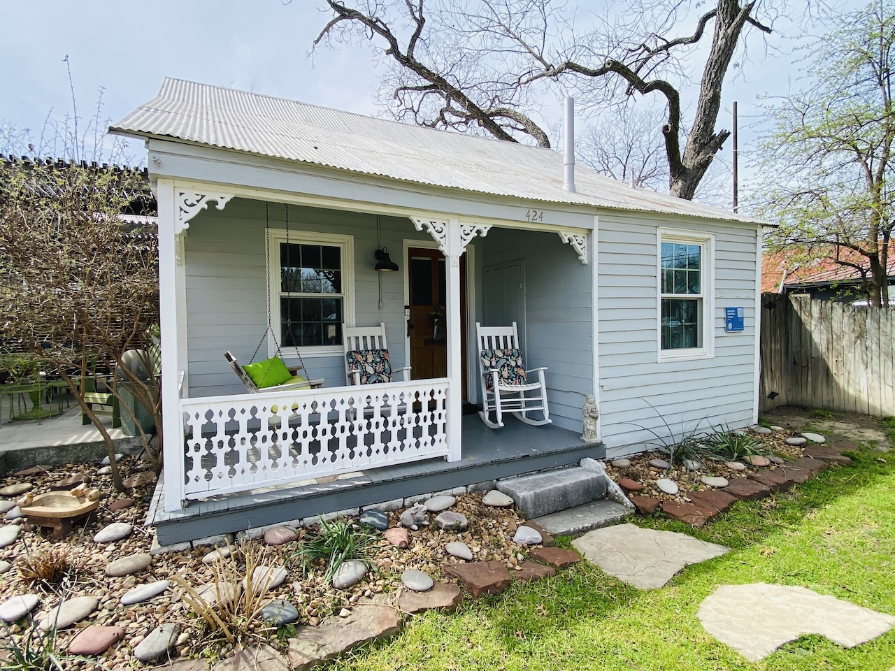 Front view of the New Braunfels Cottage featuring a covered patio and porch swing