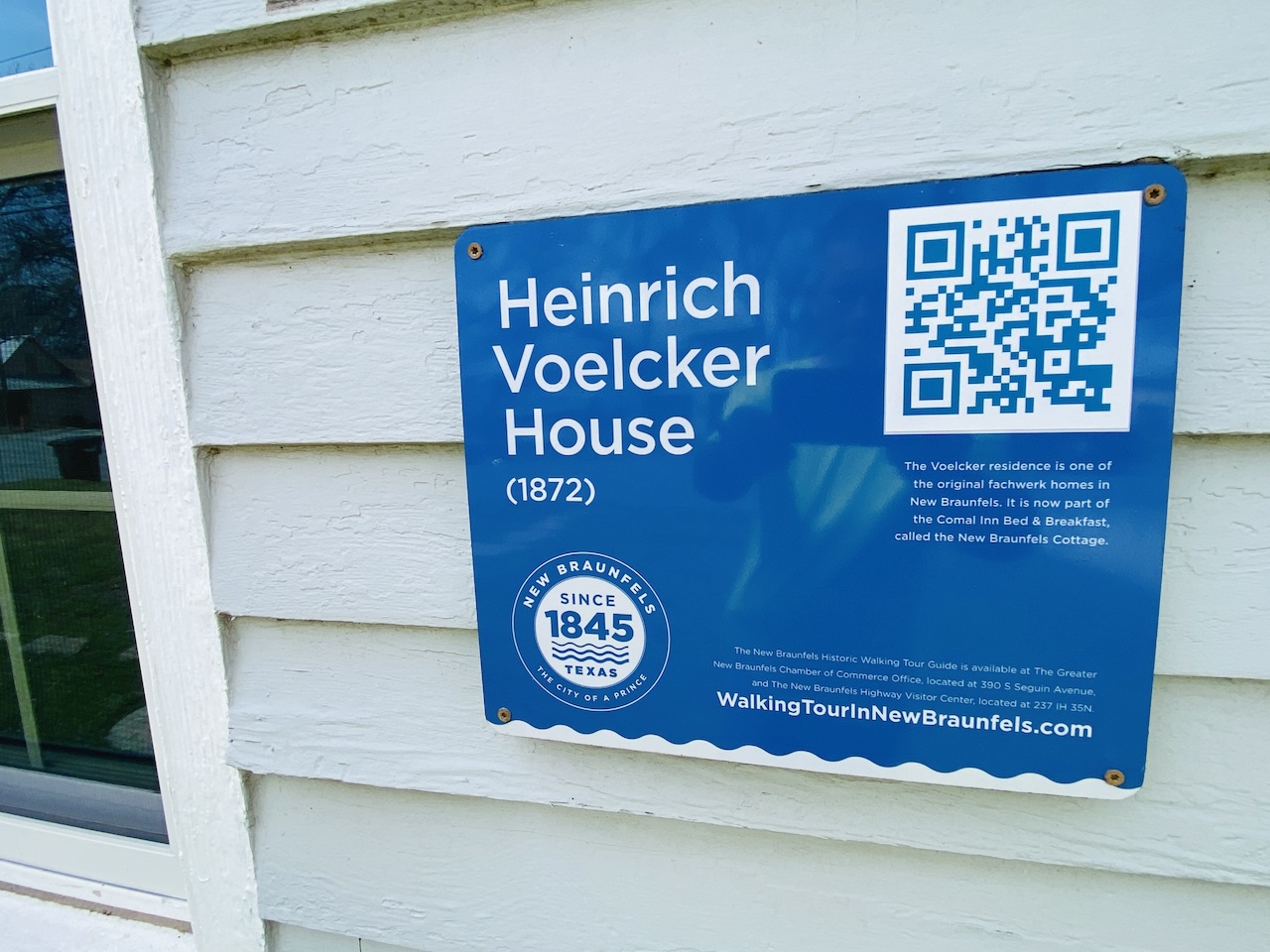 Historic placard on the exterior of the New Braunfels Cottage describing its 1872 origins