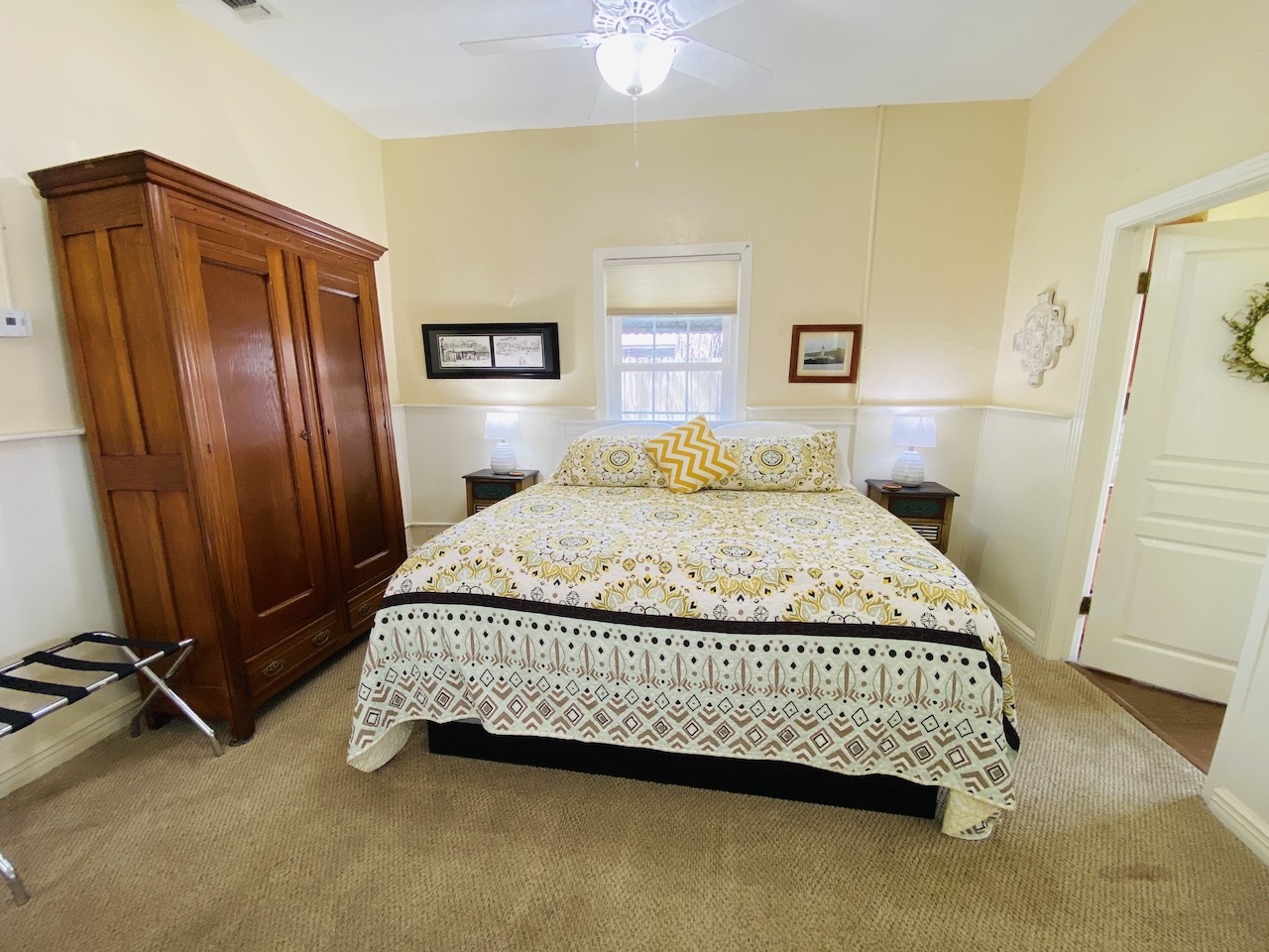 King bed located in the open living area of the New Braunfels Cottage at Comal Inn